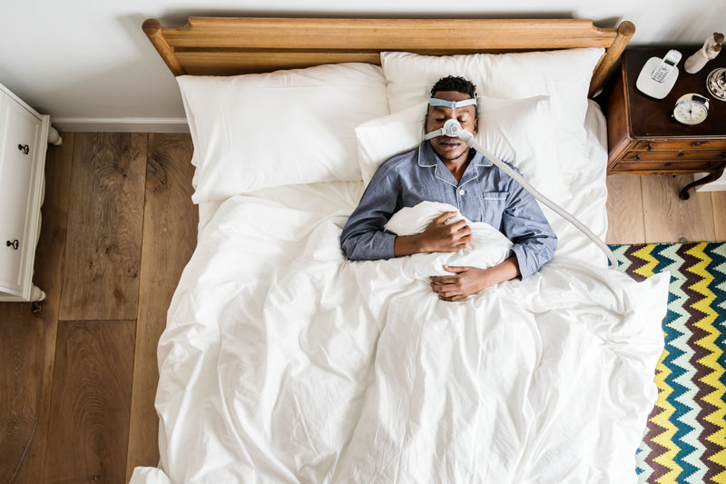man sleeping with an anti snoring mask