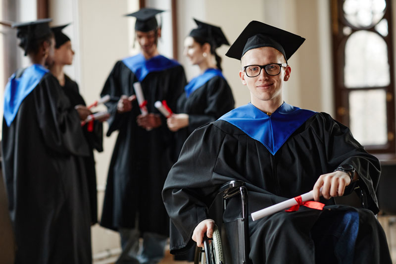 young man with disability graduating college